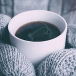 Wooly gloves holding a hot coffee