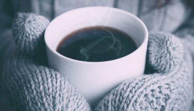 Wooly gloves holding a hot coffee